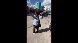 Elderly woman dances while balancing a beer bottle on her head in Nuevo Progreso, Mexico