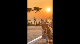 Chinese an dances with coconut in Haikou sunset
