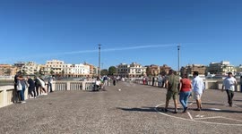 People stroll along the Lido di Ostia pier on a warm Saturday morning in the October sun in Rome.
