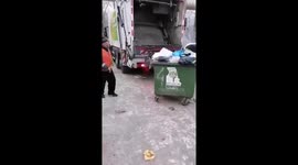 Utility worker chases rats with hockey club near garbage container in Omsk, Russia