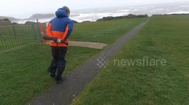 Photographer struggles to stay upright as he walks headfirst into Storm Darragh winds