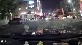 Three individuals surprised by car park barrier while crossing street in Jiangsu, China