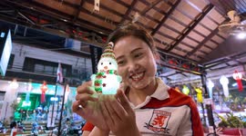 A Christmas Snowman Doll brings smiles to a waitress in Chiang Mai, Thailand
