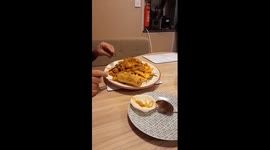 Pet mouse enjoys cracker with pasta while sitting on a plate in Norfolk, England
