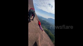 Hiker almost slides off cliff but is rescued by companion in nail-biting clip