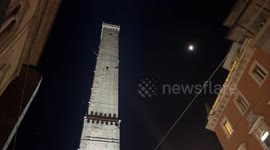 The Asinelli Tower in the evening illuminated by a light that changes from white to red in Bologna.