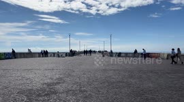 A panoramic view of the entrance square to the Ostia pier with people strolling on a sunny Sunday in October in Rome.