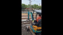 Excavator driver skillfully crosses railway tracks
