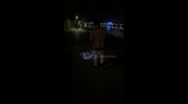 Pedestrian watches smartphone video projected onto ground in front of him