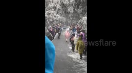 Chaos as dozens of tourists slide down icy mountain path in China