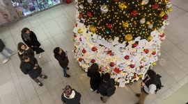 Travelers read wish cards that were hung by travelers on the decorated Christmas tree installed inside Termini Station during the Christmas season in Rome.