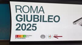 People walk along a stretch of the new corridor at the Spagna metro station in front of a newly installed display showing the slogan ‘Rome Jubilee 2025’, in Rome.