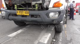 Truck trapped in barrier after swerving to avoid minibus in Indonesia