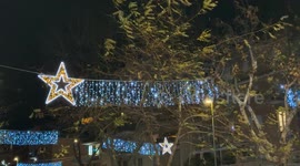 Strong winds move the branches of the trees and the strings of lights on a freezing Christmas Eve evening in December in Rome.