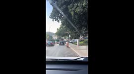 Person rides scooter while seated on attached chair in Málaga