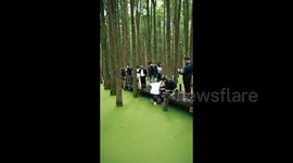 China: A Man Uses His Foot to Pick up His Phone from the Lake