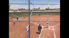 A softball player rounding third to come in home trips over her feet before...