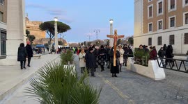 A nun carries the official Jubilee Cross 2025, the central symbol of the pilgrimage, given to each group leader of pilgrims to accompany them as they pass through the Holy Door of St. Peter's and leads the pilgrims of her group towards St. Peter's Basilic