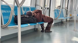 A man sleeps in a subway car traveling to the city center on Christmas Day in Rome.