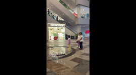 Grandmothers join little girl running through water fountain arches at mall
