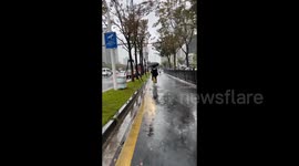 China: Cyclist Falls While Holding an Umbrella