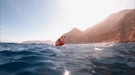 Couple kayaking in beautiful landscape at Portus beach, Spain. Aquatic sports during summer concept.