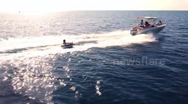 water skiing over inflatable donut pulled by motorboat. Aquatic sports, water sport during summertime, ski water donuts.