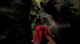 cave exploration, exploring a cavern. Young explorer walks through a narrow path in caves and caverns in Estrecho de la Arboleja or Agualeja in Murcia, Spain.