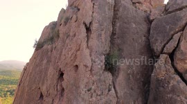 Man at mountain top after rock climbing aerial view of sportsman in La Panocha, el Valle Murcia, Spain