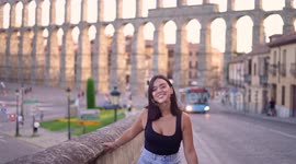 Aqueduct of Segovia visited by girl travelling to Spain walking arround this artichetectural structure which is considered as a world heritage.