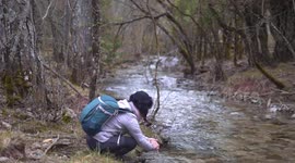 Woman relax at nature, wash hands peacefully and happy at river that crosses the forest in Mundo River, Spain