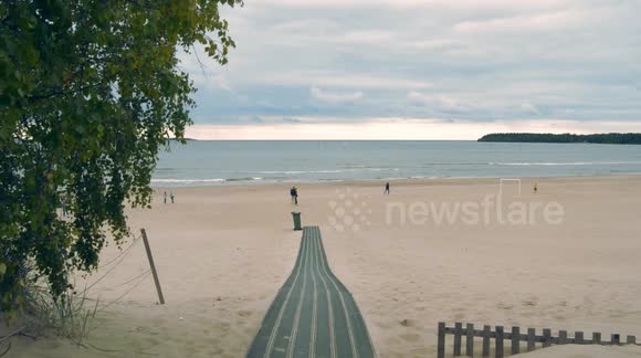 Beautiful finnish beach during summer day with a cozy vibe and a family enjoying time there.