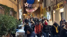 People stroll through one of the alleys of Trastevere decorated with lights during the Christmas period in Rome.