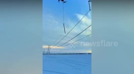 Drone with dangling de-icing sticks used to whack ice off high-up power lines