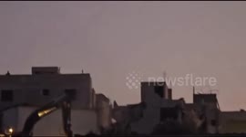 Israeli forces demolish a house in the town of Kafr Qare'