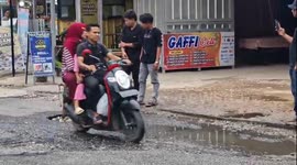 Locals irked by road condition plant a tree in giant water-filled pot hole