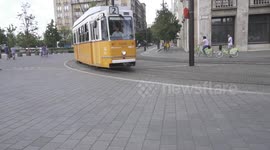 City train driving through Budapest in the afternoon near Hungarian Parliament.