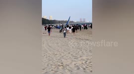 Hang glider crashes onto beach in front of shocked tourists in China