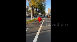 China: Homemade Roller Skier Gear Rolling on the Road by an Elderly Lady