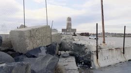 The protest sign 'no porto' on a large concrete block at the entrance to the old lighthouse in the area where Royal Caribbean plans to build the first large privately managed tourist port in Italy in Fiumicino, near Rome.