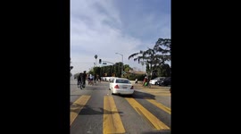 Car Races Through Large Pack Of Bicycles