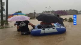Groom picks up bride in rubber boat to cross flooded road