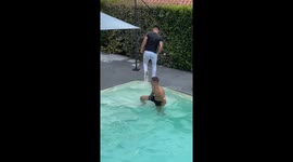 Lad takes friend down with him with a surprise pool dive