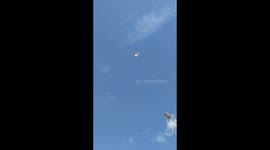 Rainbow umbrella takes off from uplift of wind on hot day