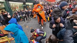 Delighted crowd squeals in Chinatown as lion dancers spray water on them in London