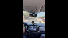 Persistent vendors stand on road to invite passing drivers to their food stalls