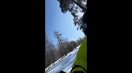Dog skis alongside owner at Zavjalikha Ski Resort in Chelyabinsk, Russia