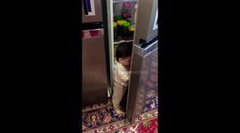 Twins play with open fridge in Jolfa, Iran