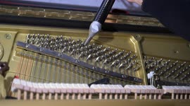 Technician tuning an upright piano and using lever and tools to tighten or loosen the strings to produce proper musical pitch in Madrid on 3 February, 2025.