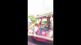 Tuk-tuk covered in Hello Kitty teddy bears cruises along road